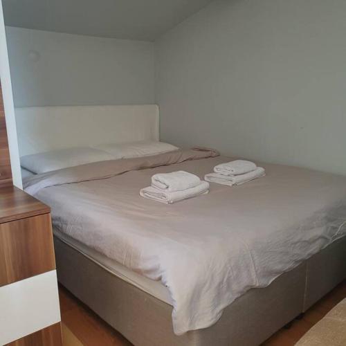 Una cama con dos toallas blancas encima. en Cosy & Spacious Terrace Flat, en Estambul