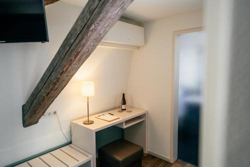 a room with a desk with a lamp and a window at Weinbar & Gästehaus Himmelstoss in Dettelbach