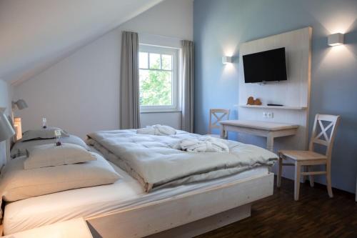 a bedroom with a bed and a desk and a television at Schwarzwald Chalets in Freudenstadt