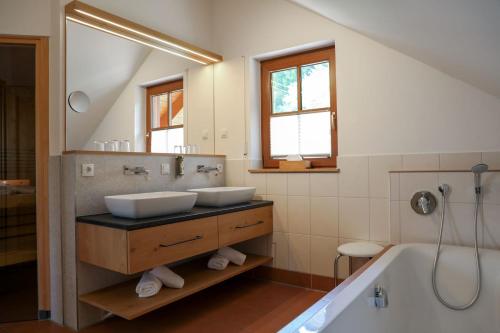 ein Badezimmer mit 2 Waschbecken und einer Badewanne in der Unterkunft Schwarzwald Chalets in Freudenstadt