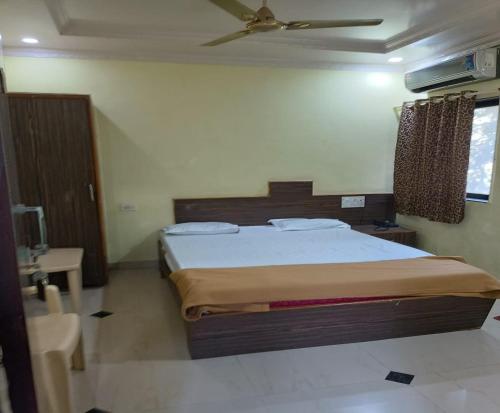 1 dormitorio con 1 cama y ventilador de techo en Hotel Rachana Residency en Pune