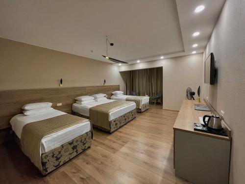 a hotel room with four beds in a room at Hotel Gloria Deluxe in Borovoye