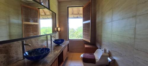 a bathroom with two blue sinks and a toilet at Sanur Seaview Hotel in Sanur