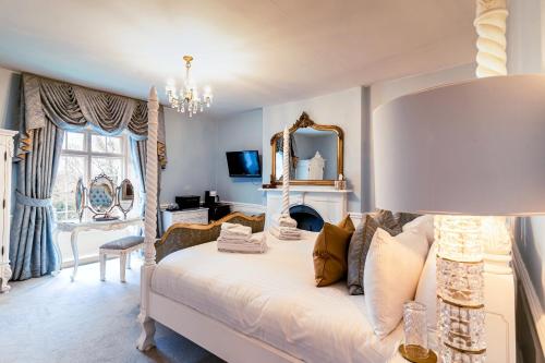 a bedroom with a white bed and a mirror at Plas Dinas Country House in Caernarfon