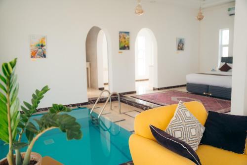 a living room with a yellow couch and a table at Jawharat Bidiyah Resort "JBR" in Al Ghabbī