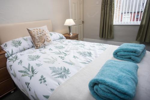 ein Schlafzimmer mit einem Bett mit blauen Handtüchern darauf in der Unterkunft Bell Street in Liverpool