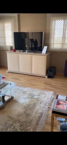 uma sala de estar com uma televisão de ecrã plano e uma mesa em Superbe Villa au bord de la mer. em Tamaris