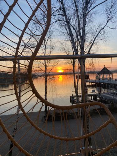 a view of a lake with the sunset in the background at Apartament MoLoo I in Ostróda