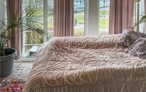 Bett in einem Zimmer mit einem großen Fenster in der Unterkunft Gorgeous Apartment In Bors With Wifi in Borås