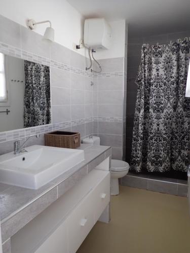 uma casa de banho branca com um lavatório e um WC em Casa Velha Penthouse em Sal Rei