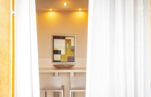 a room with a table with chairs and a painting at Réva Residences and Pool in Monforte dʼAlba