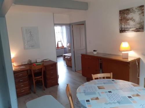 Pokój ze stołem i biurkiem oraz kuchnią w obiekcie Appartement accueillant au cœur de La Margeride w mieście Grandrieu