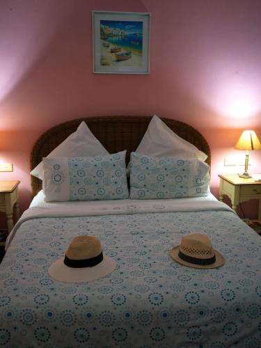 two hats sitting on top of a bed at Las Flores Beachside Hotel in Catmon