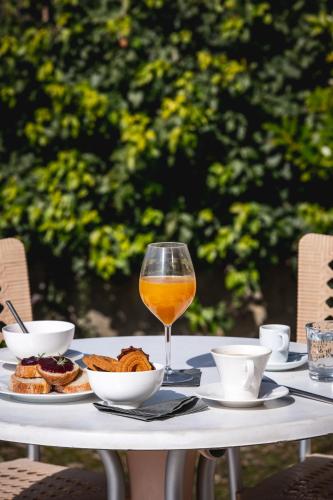 a table with a glass of orange juice and food at Réva Residences and Pool in Monforte dʼAlba