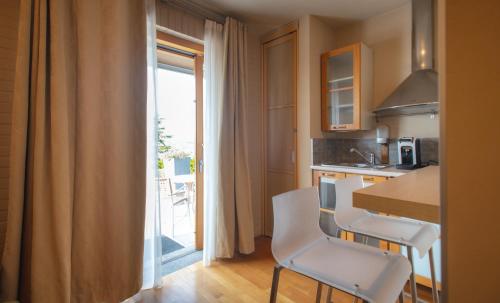 a kitchen with a table and chairs and a balcony at Réva Residences and Pool in Monforte dʼAlba