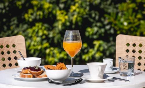 a glass of orange juice sitting on a table with food at Réva Residences and Pool in Monforte dʼAlba