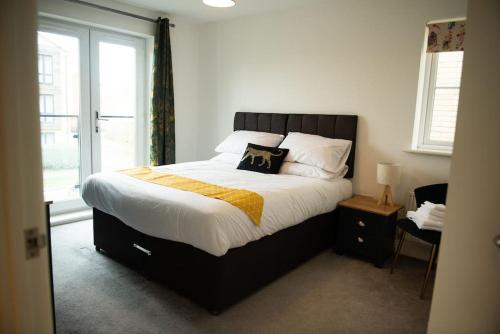 a bedroom with a large bed with a large window at Chi-Amici-3bed home-St Neots-Near to train station in Saint Neots