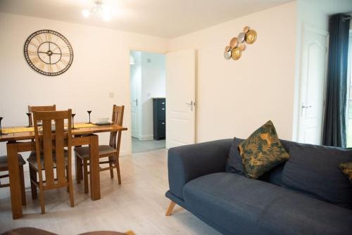 a living room with a blue couch and a table at Chi-Amici-3bed home-St Neots-Near to train station in Saint Neots