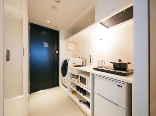 uma cozinha com uma porta preta num quarto em East SQUARE Tokyo em Tóquio