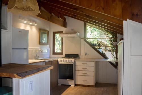una cocina con electrodomésticos blancos y una escalera en Pinamar Bosque en Pinamar