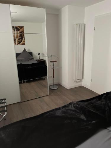 a bedroom with a mirror and a bed in it at Propeller Gästehaus OG in Eppingen