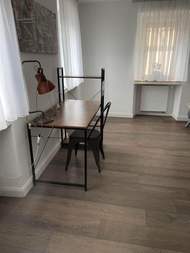 a table with a lamp and a chair in a room at Propeller Gästehaus OG in Eppingen