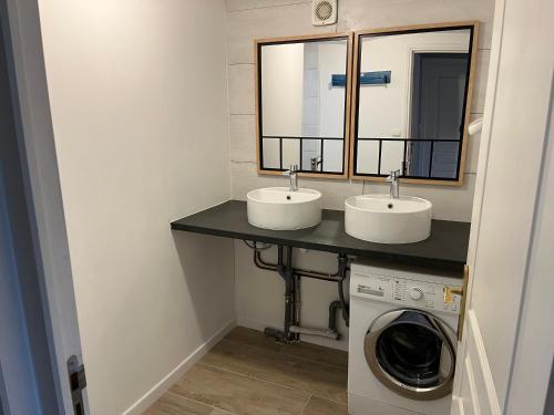 a bathroom with two sinks and a washing machine at Maisonette La Quiétude in Wimereux