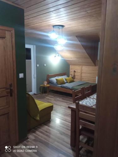 a bedroom with a bed and a couch in a room at Apartament 4 osobowy in Kujan