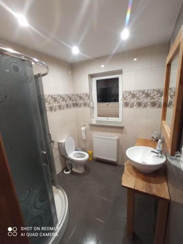 a bathroom with two toilets and a shower and a sink at Apartament 4 osobowy in Kujan
