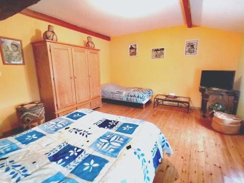 a bedroom with a bed with a blue and white blanket at quietude in Lagorce