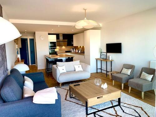 sala de estar con sofá azul y sillas en Le Touquet : Appt 4 pers face mer en Le Touquet-Paris-Plage