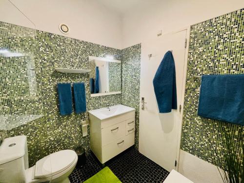 カスカイスにあるStudio Cascais with Sea viewのバスルーム(トイレ、シャワー、青いタオル付)