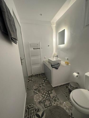 uma casa de banho branca com um lavatório e um WC em White and Grey Tinos em Stení