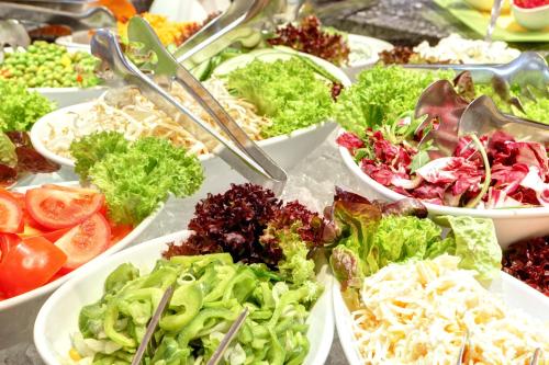 a buffet filled with different types of salads in bowls at ABACUS Tierpark Hotel in Berlin