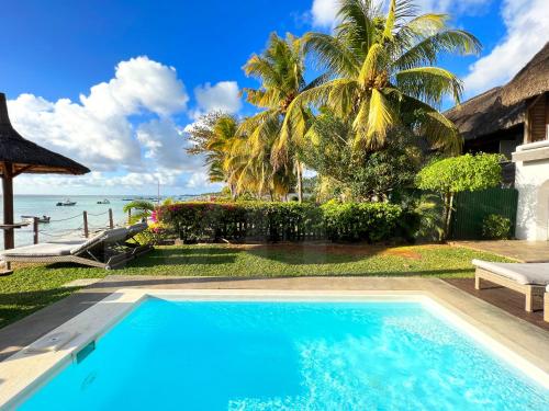 a swimming pool with a view of the ocean at Caro's Beachfront in Trou aux Biches