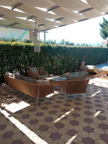 a patio with chairs and a table and a hedge at Luxury Villas Chrysa Private Pool & Spa in Nafplio