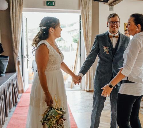 a bride and groom holding hands during their wedding ceremony at Schliefauhof in Randegg