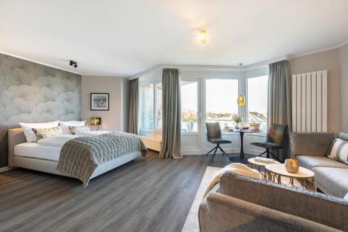 um quarto com uma cama e uma sala de estar em NEU! Ferienwohnung Sunset Loft Wohlfuehlatmospaehre mit Weitblick in Westerland Sylt em Westerland