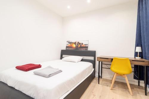 1 dormitorio con cama, escritorio y silla amarilla en ZenBNB / L'Exploreur / 2 Min. Tram / Centre-Ville, en Annemasse
