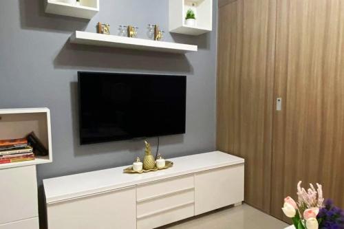 a living room with a flat screen tv on a wall at Fully equipped 1BR Condo at Shore2 near to MOA in Manila