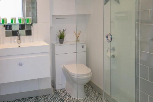 a white bathroom with a toilet and a shower at George Hotel, BW Signature Collection in Norwich
