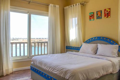 a bedroom with a bed and a large window at El Gouna Lagoon Paradise Penthouse in Hurghada