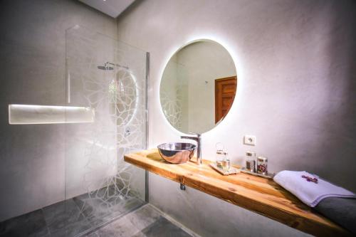 a bathroom with a mirror and a sink and a shower at Villa Taj Sofia & Spa in Marrakech