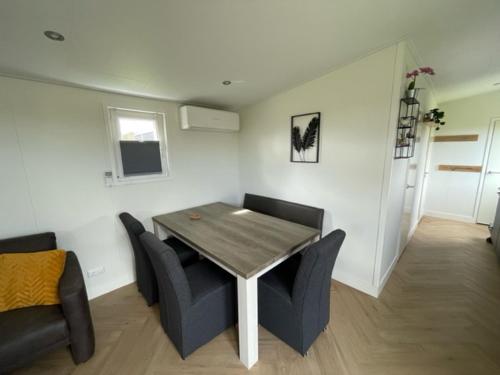 Chalet 't Kwedammertje في Kwadendamme: غرفة معيشة مع طاولة وكراسي خشبية