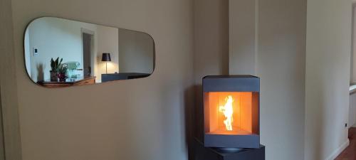 a candle on a wall in front of a mirror at Domus Fontis Pescaia in Spoleto