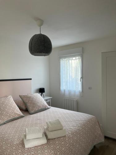 a bedroom with a bed with two towels on it at Le Hameau du Peu in Châteauvieux