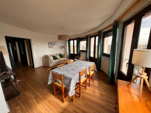 salon ze stołem, krzesłami i kanapą w obiekcie Appartement lumineux centre ville w mieście Châteauroux