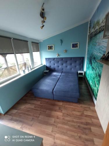 a room with a large blue bed and an aquarium at domek nad jeziorem in Kujan