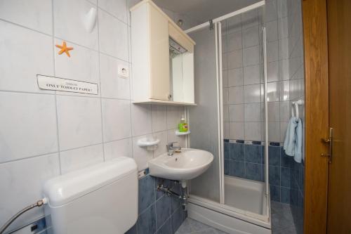 a small bathroom with a sink and a shower at Apartmani Lory in Tribunj