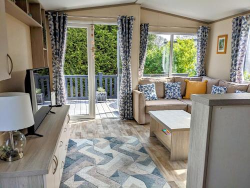uma sala de estar com um sofá e uma mesa em Modern 2 Bedroom Mobile home with parking on St Helens Coastal Resort Isle of Wight em Saint Helens